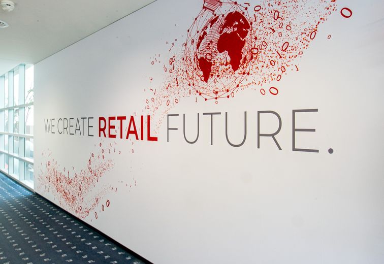 Großflächige Aufschrift "We create retail future" in Gang