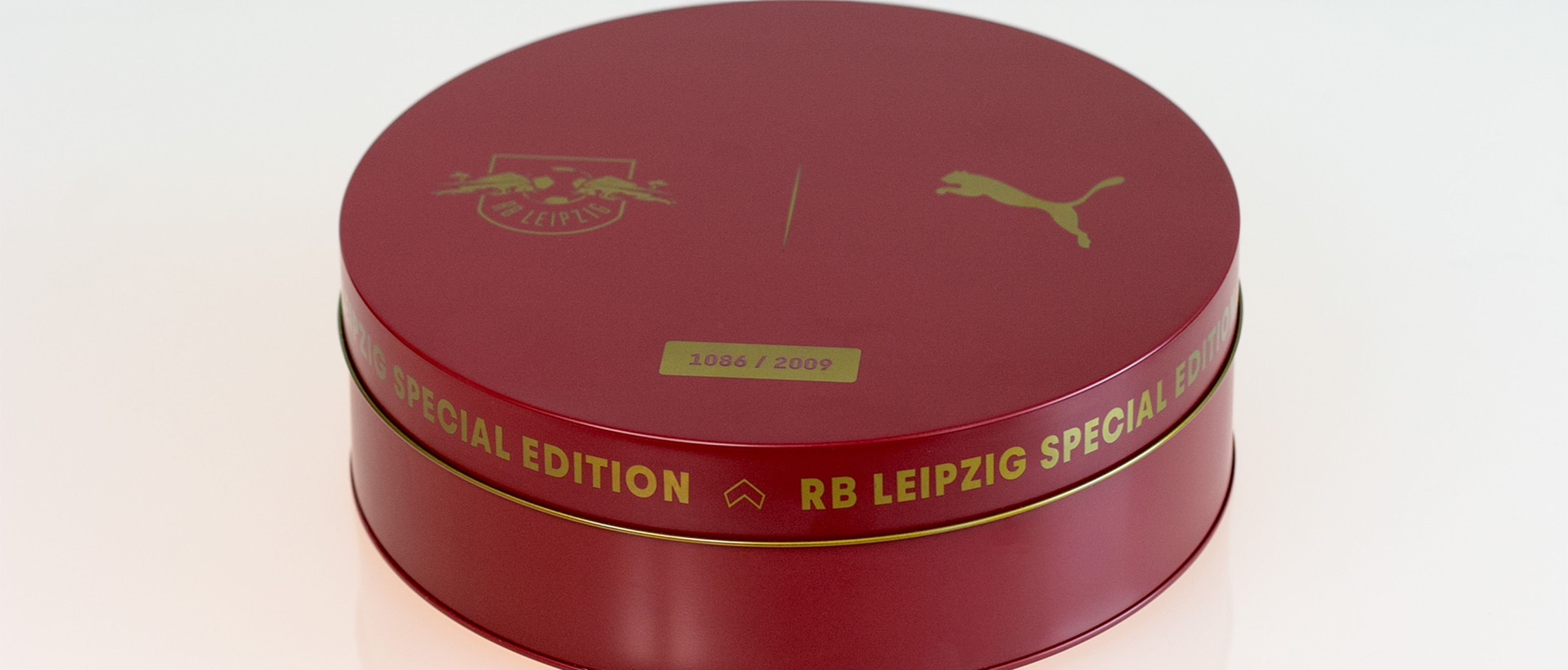 Rote, runde Dose mit goldfarbener Aufschrift „RB Leipzig Special Edition“. Mit Puma-Logo und Vereinswappen, gekennzeichnet mit „1086/2009“.