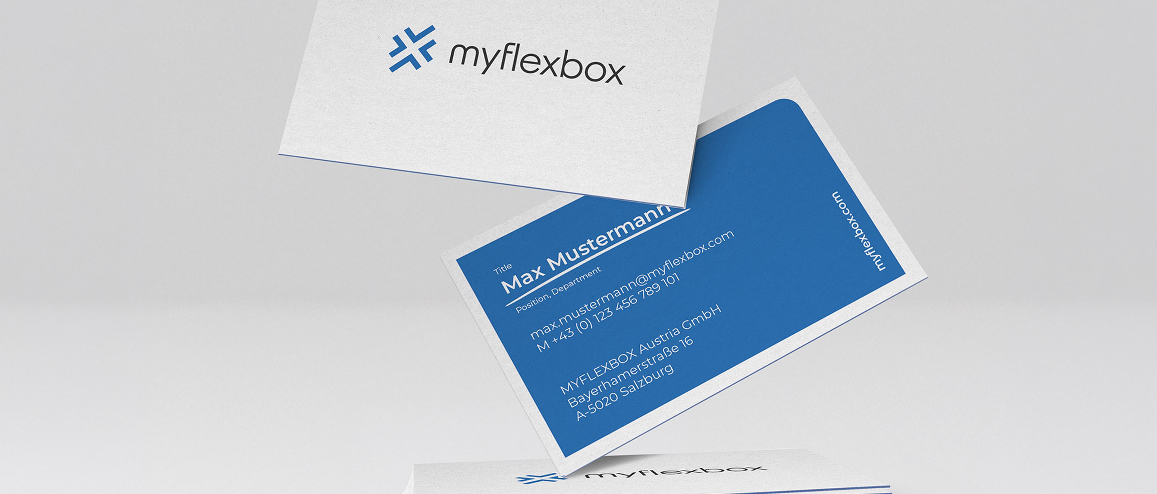 Ein Stapel Myflexbox-Visitenkarten, auf der Vorderseite mit Logo und auf der Rückseite mit Kontaktdaten, darunter Name und Adresse, vor hellem Hintergrund.